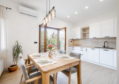 Stol posložen za četvero i otvorena vrata na terasu našeg šarmantnog apartmana Lumbarda