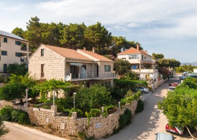 Pogled iz zraka na šarmantni apartman Lumbarda s cestom i dvorištem s vinovim lozama i biljkama
